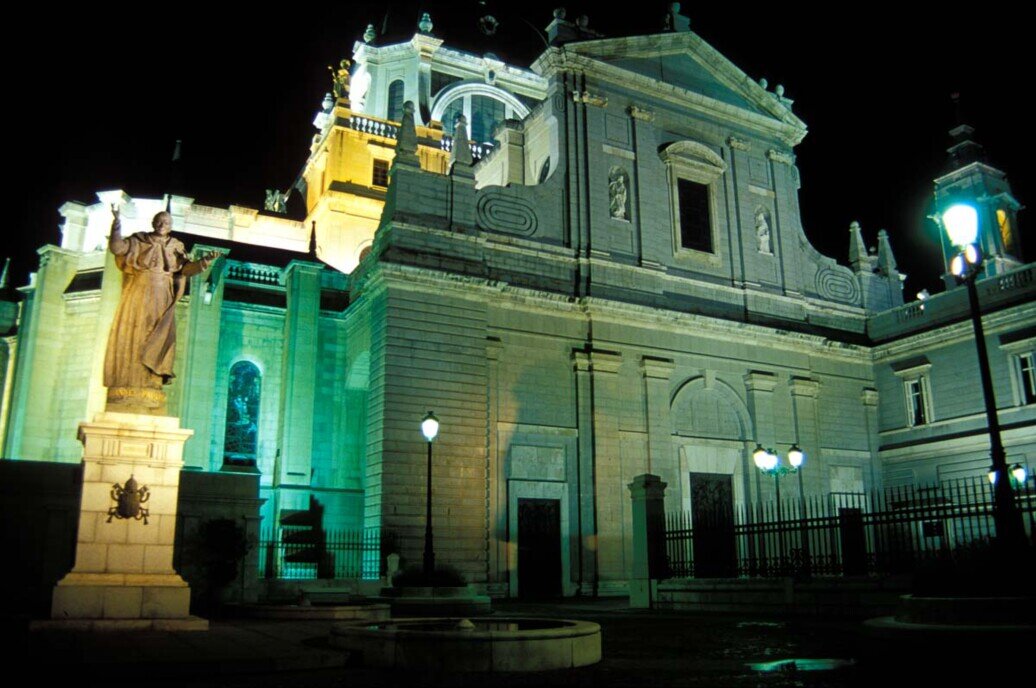 La Cattedrale dell’Almudena a Madrid vista dall’esterno di notte, con la facciata illuminata e il cielo scuro sullo sfondo.Catedral de la Almudena
