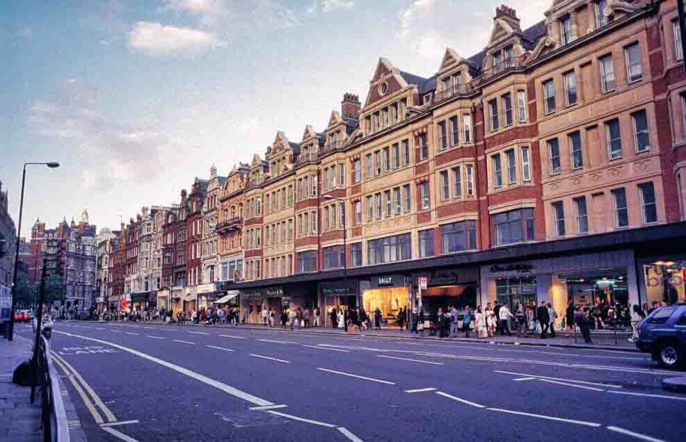 Brompton Road Una strsada con strisce angolate e palazzi e negozi eleganti