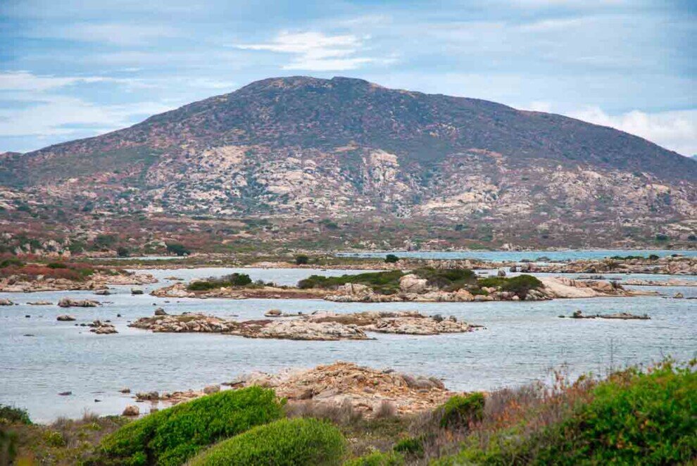 Il mare con al centro isolotti di roccia e sullo sfondo una collina all'Isola dell'Asinara
