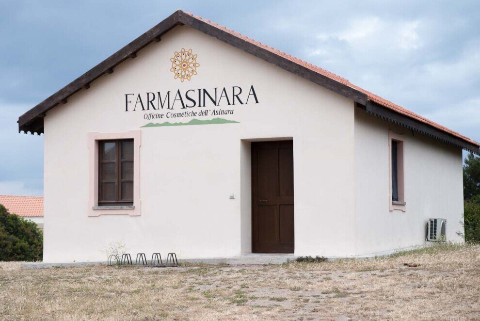 Un caseggiato bianco a tetto spiovente con la scritta Farmasinara