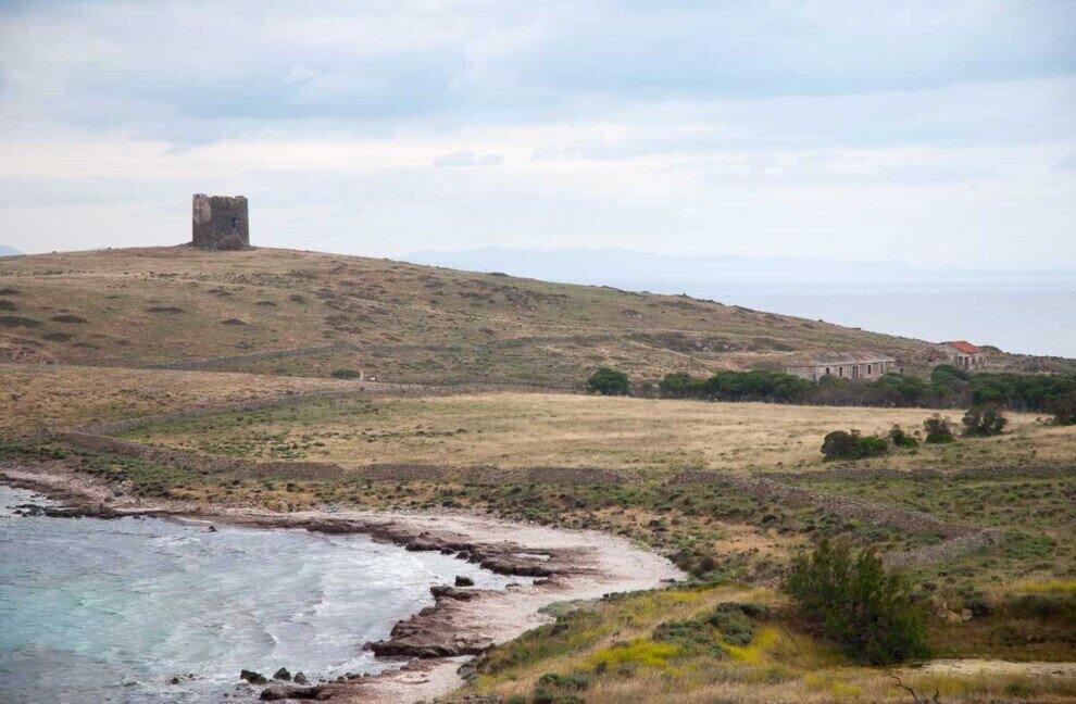 Un lembo di mare e una collinetta con una torre militare abbandonata.