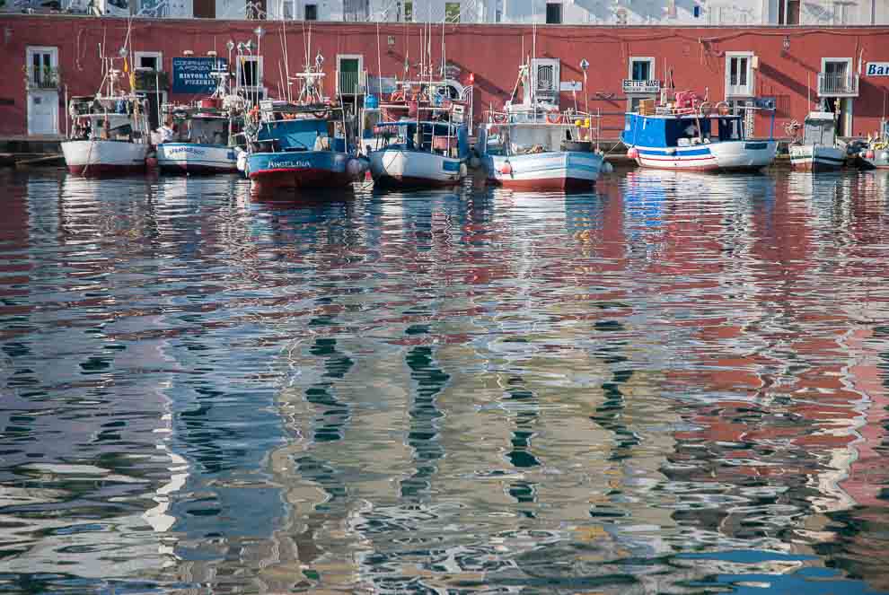 Il mare appena increspato riflette i colori delle imbarcazioni ancorate al porto di Ponza.