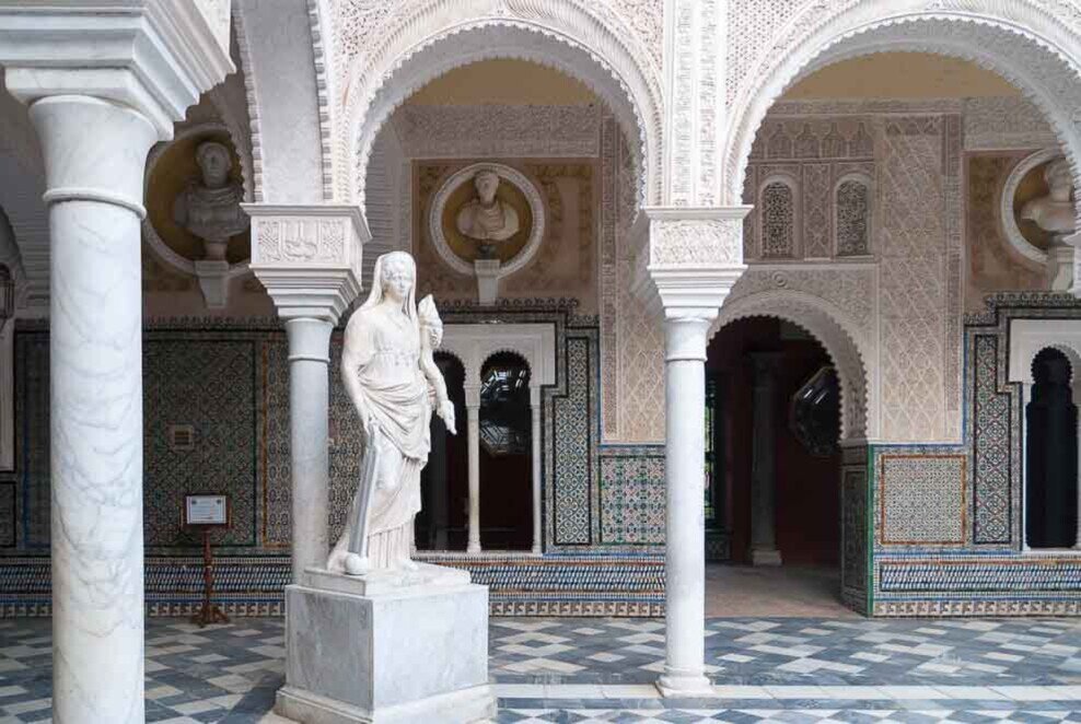 Casa de Pilatos a Siviglia Statua con sullo sfondo numerosae arcate nella Casa de Pilatos a Siviglia