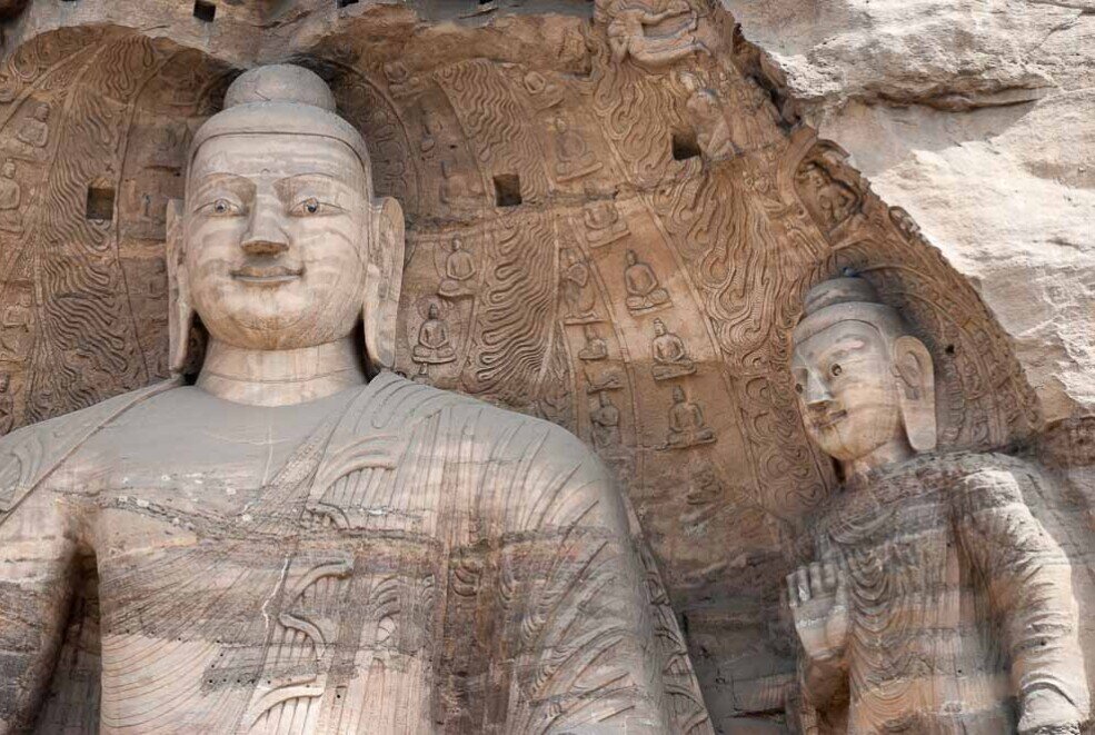 Nell'incavo di una grotta primi piani di Sakyamuni e di un Bodhisattva
