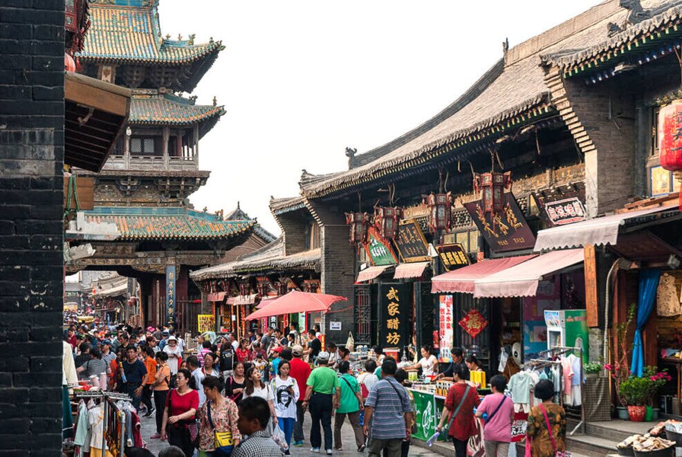 Pingyao con i suoi edifici in legno antichissimi ricchi di colore e trasformati in negozi e ristoranti pieni di turisti sulla strada