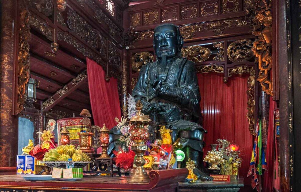 Statua in bronzo nero alta 4 metri di Saint Tran Vu con in mano un serpente e una tartaruga.