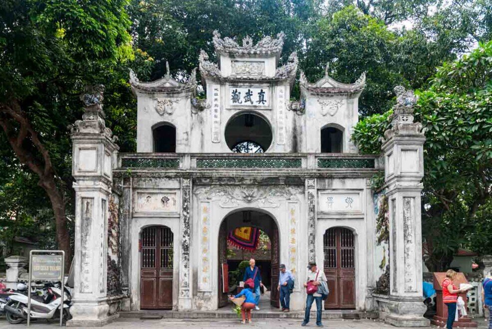 Un grande edificio bianco con ampi archi sulla facciata al tempio Quan Thanh