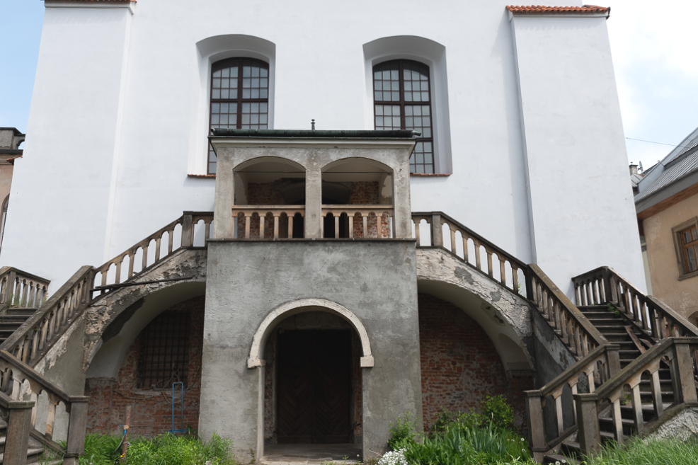 Struttura bianca con scale ai lati dell'ingresso alla Sinagoga di Izaak a Cracovia, un importante luogo di culto e storia ebraica.
