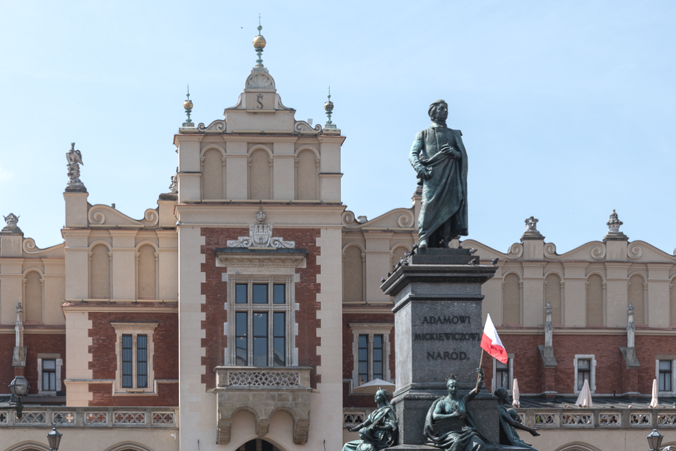 Statua di Adam Mickiewicz davanti al Mercato dei tessuti di Cracovia, un simbolo della cultura e della storia locale.