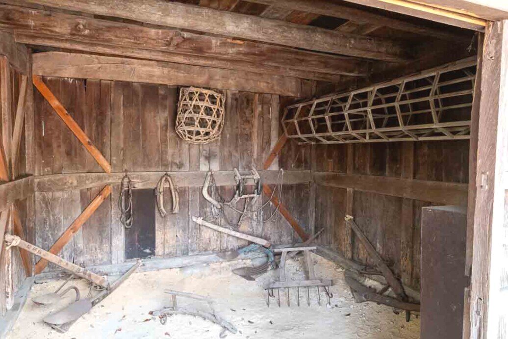 Hida Folk Village attrezzi agricoli Grande vano con pavimento in terriccio per raccogliere attrezzi agricoli come zappe-asce-collari di cavalli.