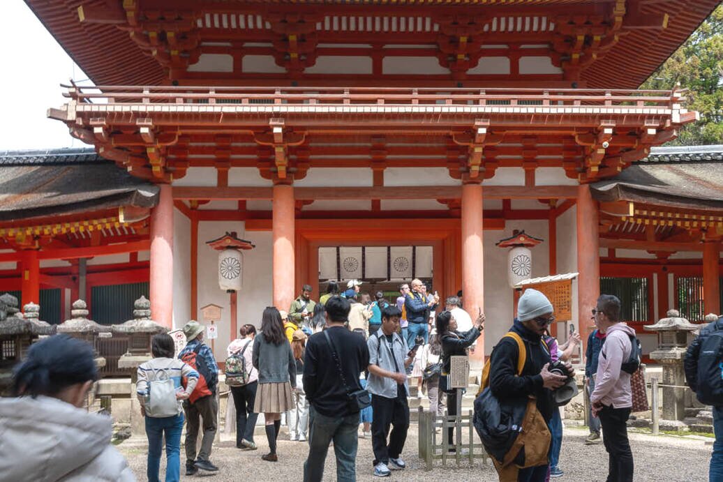 Il Minamimon è la porta sud di Kasuga-Taisha Visitatori esplorano il tempio Kasuga-Taisha, ammirando il Minamimon, la porta sud del complesso.