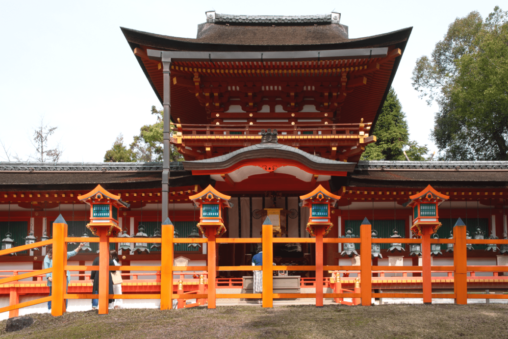 La porta centrale vermiglio della sala principale di Kasuga-Taisha. Edificio rosso imponente con tetto, con la porta centrale del santuario Kasuga-Taisha.