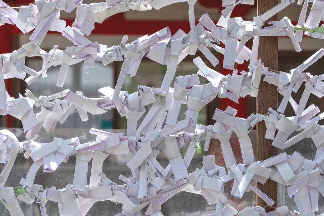Gli omikuji le strisce di carta con le scritte del proprio destino Strisce di carta legate a fili paralleli in cui sono scritte le previsioni per il proprio futuro