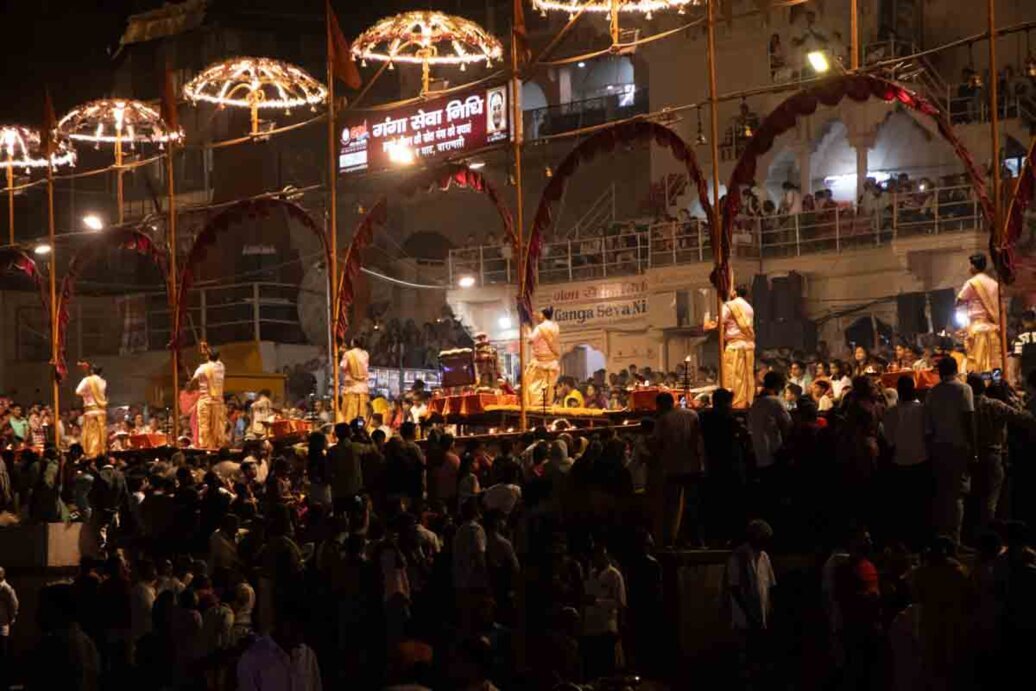Cerimonia Aarti serale a Varanasi Folto pubblico attorno a un palco illuminato di notte per la Cerimonia Aarti a Varanasi.
