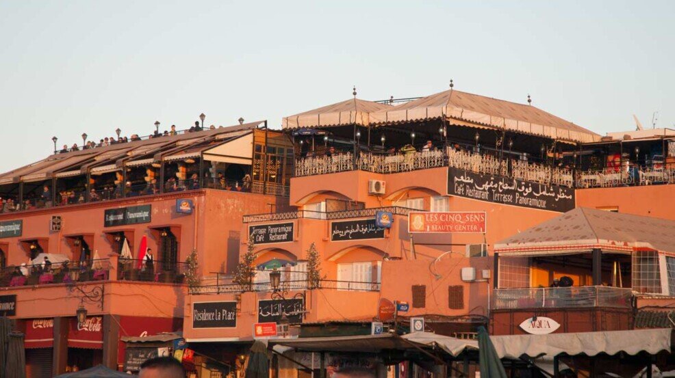 Marrakech, Piazza Jeema El Fna Edifici che circondano la piazza pieni di botteghe e ristoranti posizionati nei piani alti da dove si ammira la piazza dall'alto.