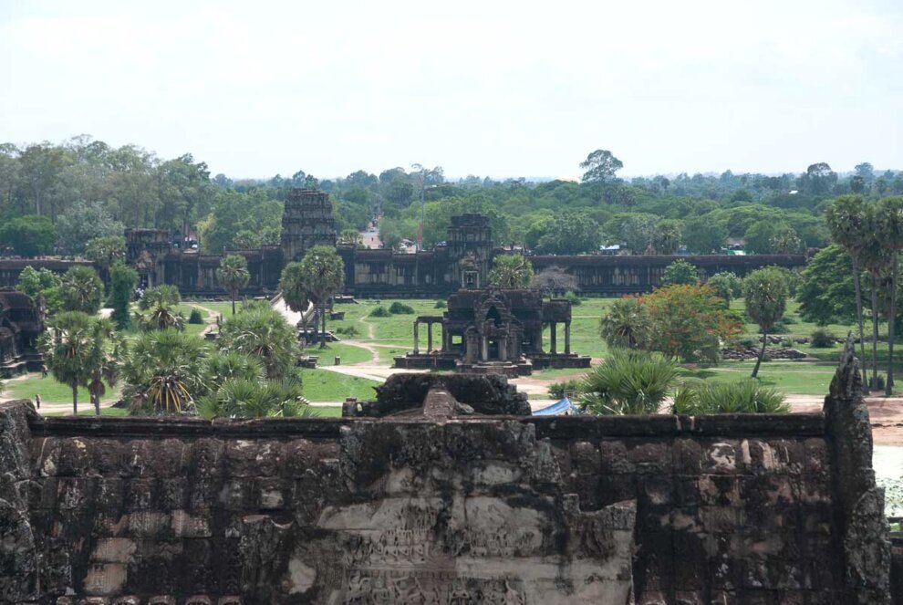 Vista panoramica dell'ingresso di Angkor ripreso dal punto più alto. C'è un grande cortile con alberi e giardini ed è fiancheggiato da due biblioteche.