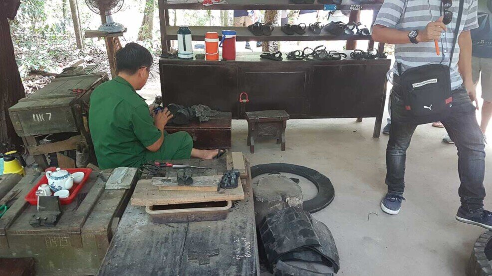 Un uomo dimostra come gli artigiani del tempo fabbricavano le scarpe per i soldati vietnamiti.