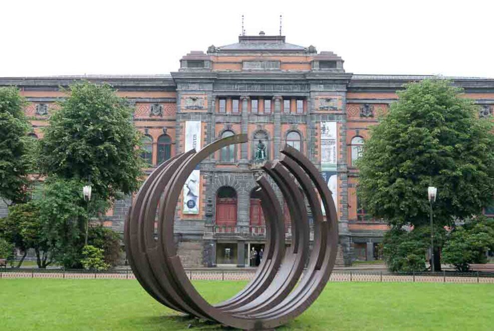 Un monumento formato da tre grandi cerchi con sullo sfondo il museo Kode 1 di Bergen.