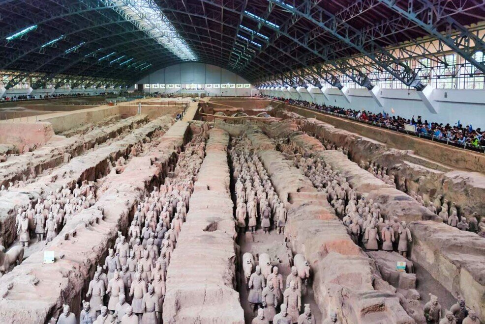 Statue dell'esercito di terracotta di Xi'an disposti in fila all'interno di un grande hangar.