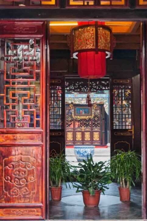 Tipico cortile a Pingyao con lampade rosse e vasi di piante.