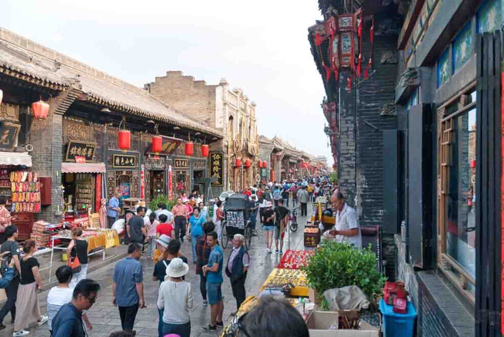 Pingyao case antiche adibite a negozi. Una strada con case antiche e lanterne appese a Pingyao