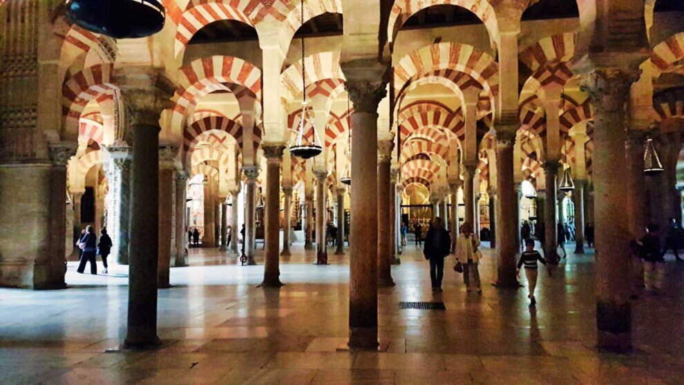 Decine di colonne con archi sovrapposti sia di lato e in profondità nella moschea di Cordova.