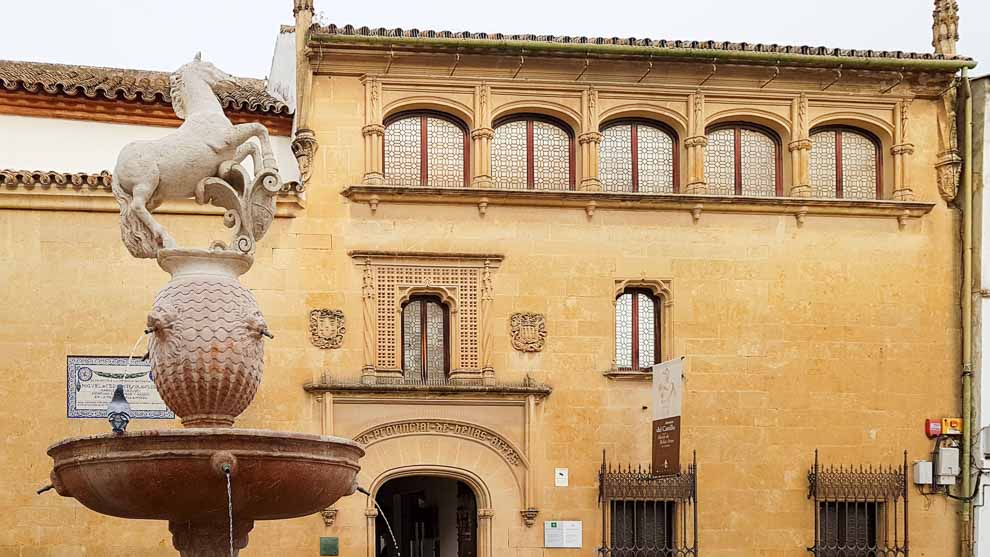 Famosa Fontana del Potro, sormontata da una statua di un puledro, con sullo sfondo l'edificio che ospita il Museo de Bellas Artes.