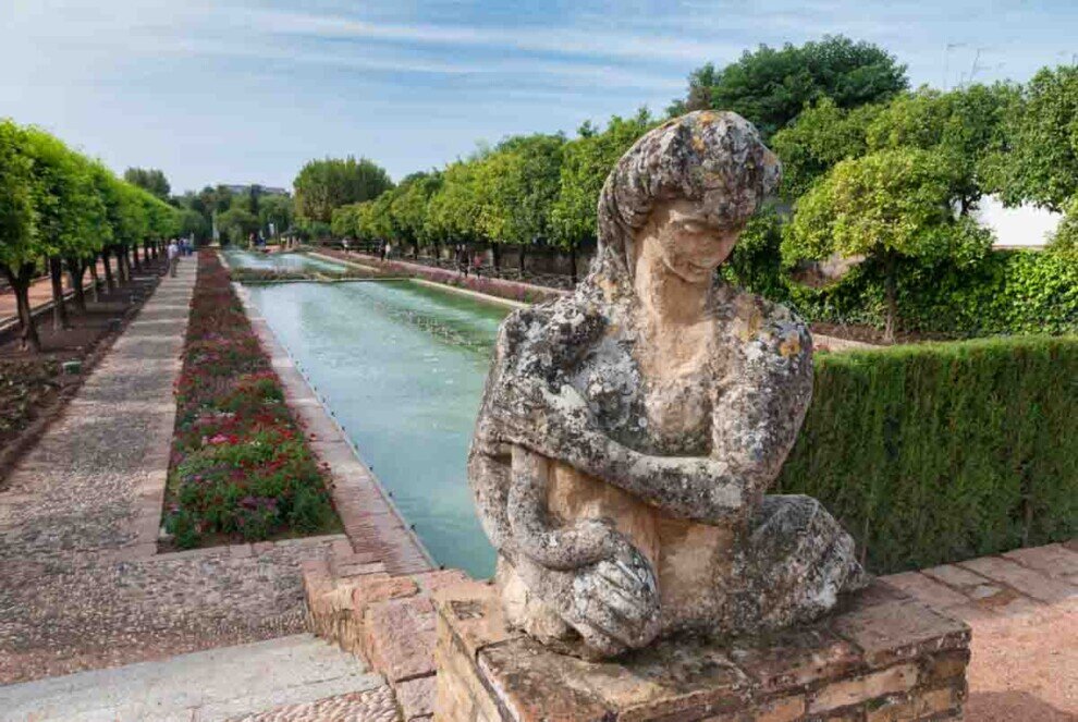 La statua in primo piano raffigura un momento di quiete all'interno di questi storici giardini andalusi.