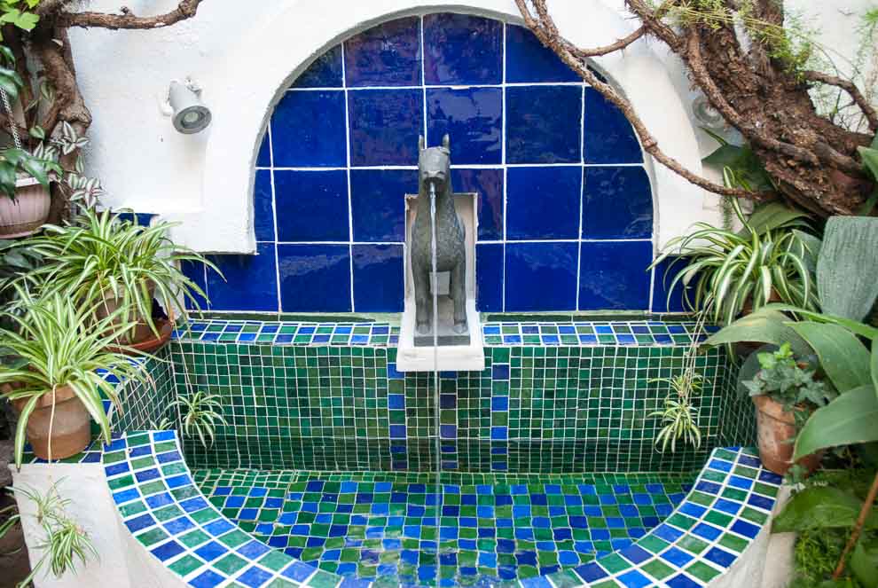 Caratteristica fontana decorata con piastrelle tradizionali, inclusi mosaici verdi e blu, e presenta una scultura a forma di cavallo come elemento centrale.