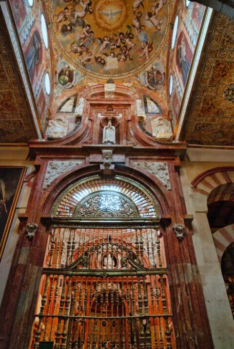 Dietro una recinzione appare la Cappella di Nostra Signora della Concezione con un altare, mentre la cupola soprastante è decorata con affreschi murali raffiguranti angeli.