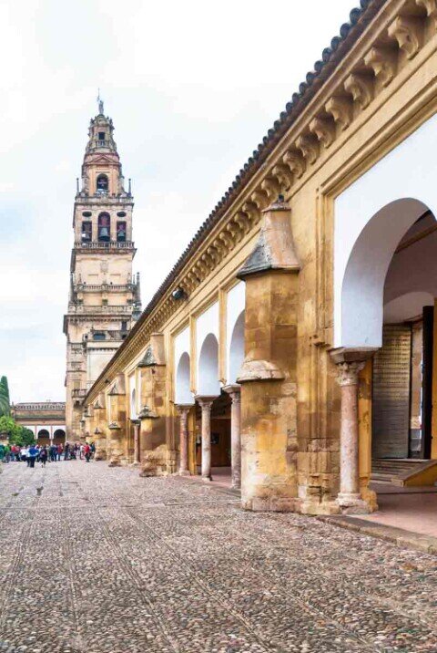 Un cortile con tanti archi con sullo sfondo un minareto.
