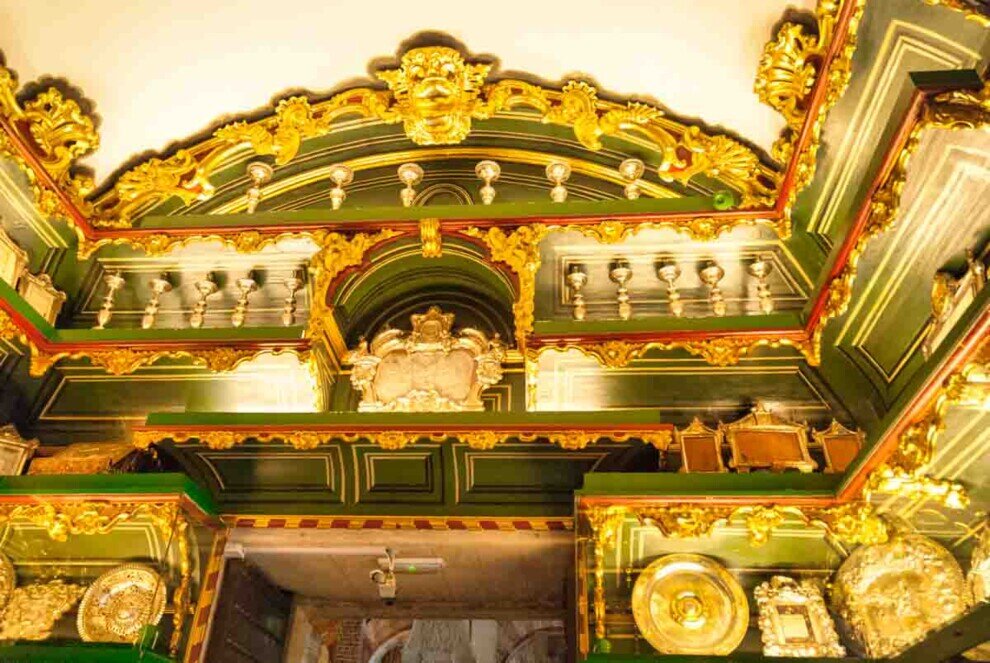 Sala del tesoro della Mezquita di Córdoba con soffitto barocco dorato e oggetti preziosi esposti in vetrine.
