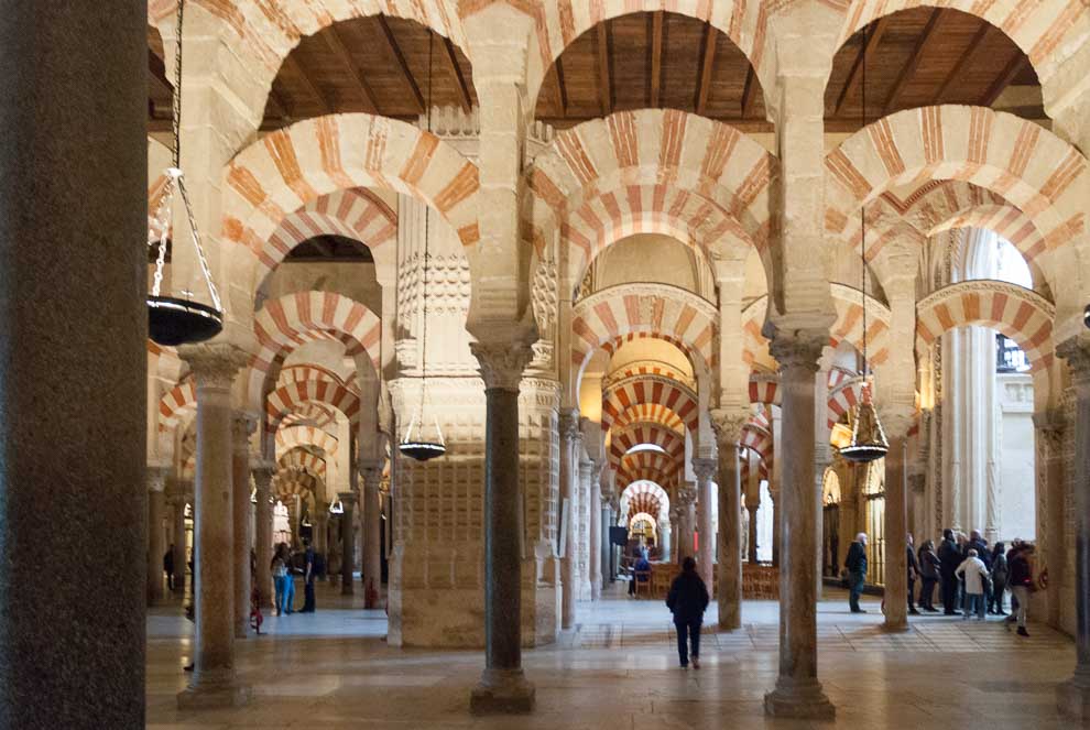 Decine di colonne con archi sovrapposti sia di lato e in profondità nella moschea di Cordova.