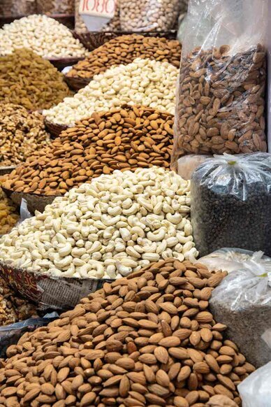 Un banco al mercato con grandi quantità di frutta secca e semi.