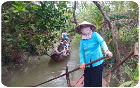 Una donna vietnamita con il caratteristico cappello voga nel fiume Mekong.