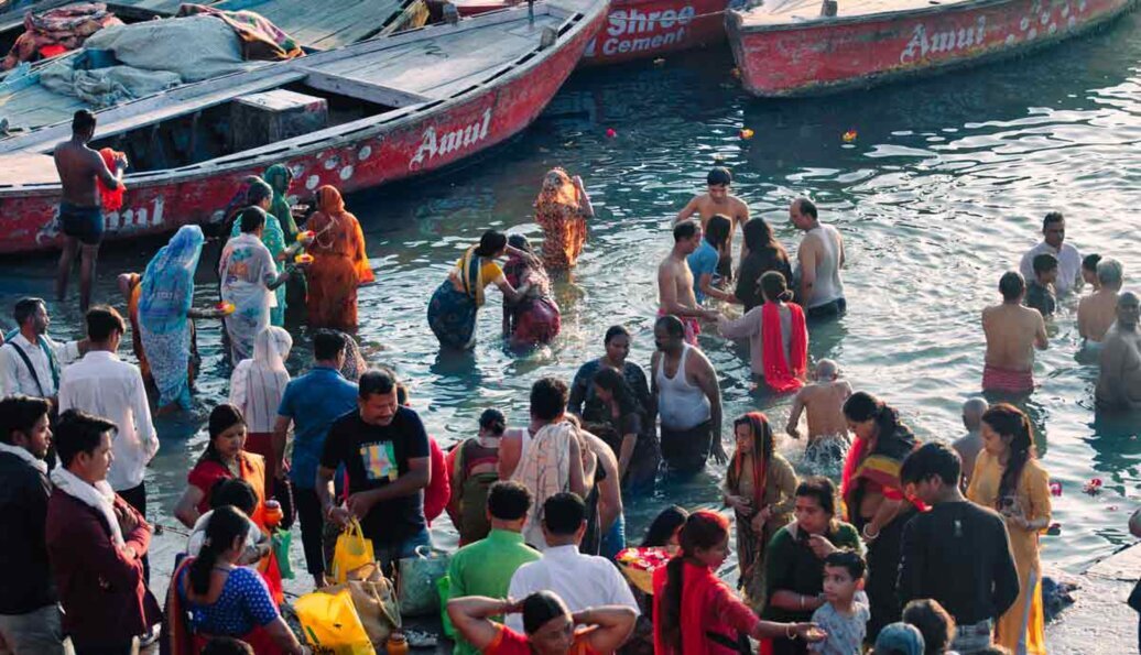 Pellegrini e i locali fanno il bagno sacro Folto gruppo di persone fanno il bagno sul Gange per purificarsi.