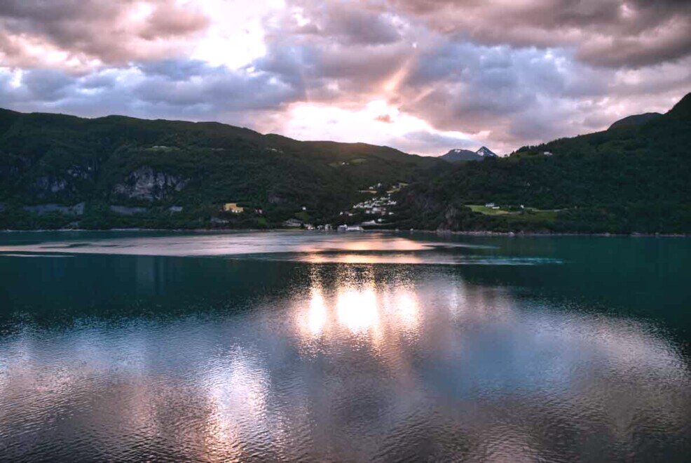 Geiranderfjiord riflessi dell'alba sull'acqua Un cielo con nuvole multicolori che si riflettono sull'acqua del GeiranderfjiordGeiranger Fjord Norvegia