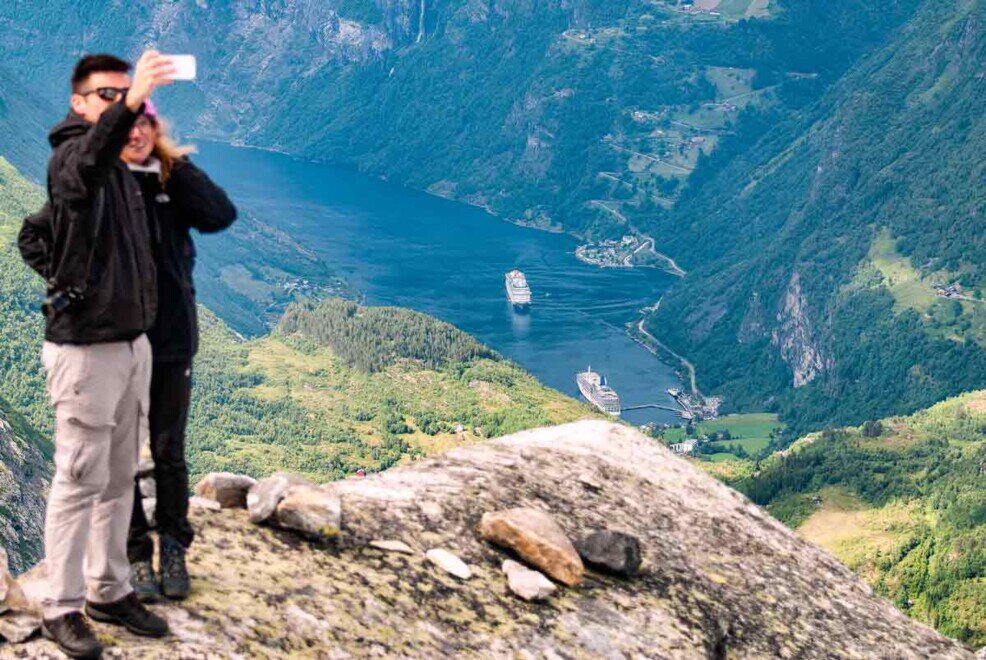 Dal Monte Dasnybba, in basso, è visibile il porticciolo di Geiranger Una coppia si fa un selfie sopra il monte Dasnybba con in basso il porticciolo di Geiranger