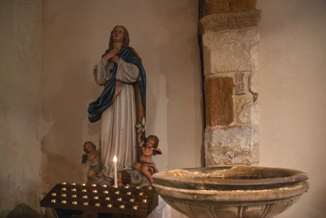 Particolare dell'acquasantiera in pietra vulcanica.