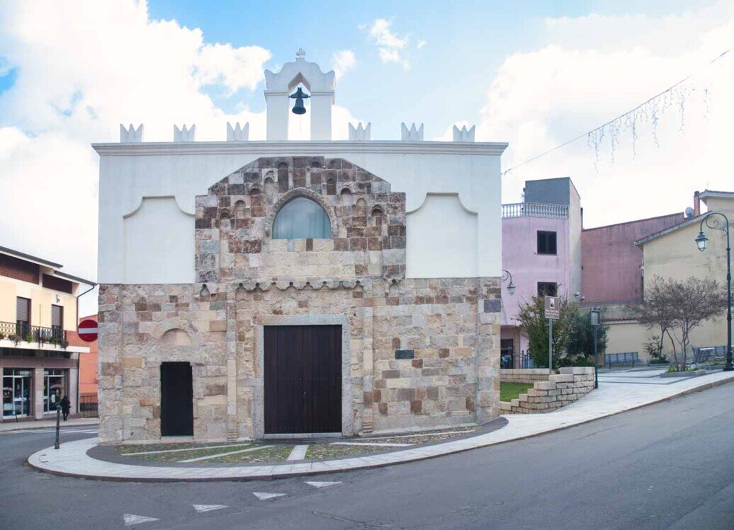 Facciata della chiesa di Santa maria di Guspini, con un portale più grande sormontato da una finestra e uno più piccolo con una croce di Malta scolpita nell'architrave,