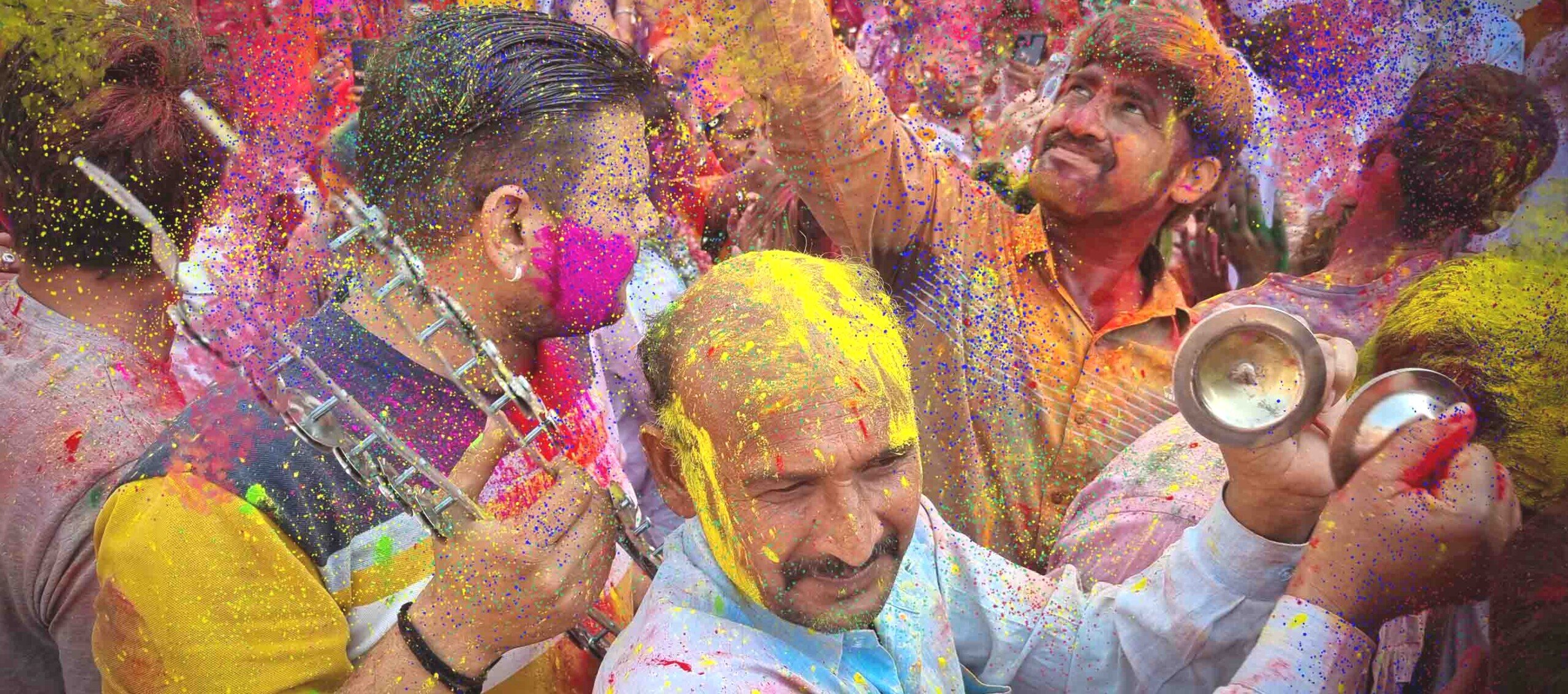 Persone in festa con lanci di polveri colorate all'holi festival.