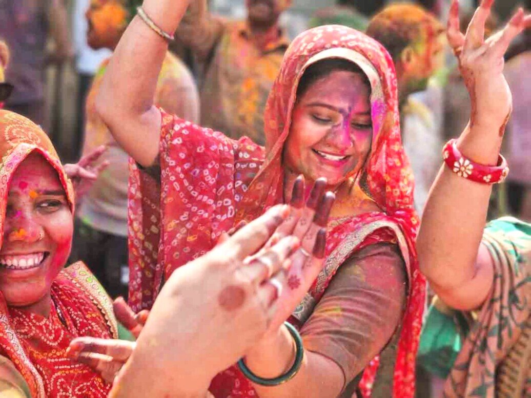 Holi festival ragazza che balla Due donne con braccia sollevate che ballano all'holi festival.