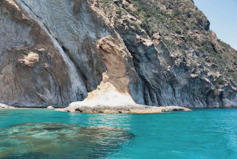 Isola di Palmarola-Scoglio dello Spermaturo Uno scoglio sottile e alto con la base larga che si erge sul mare smeraldo dell'Isola di Palmarola.