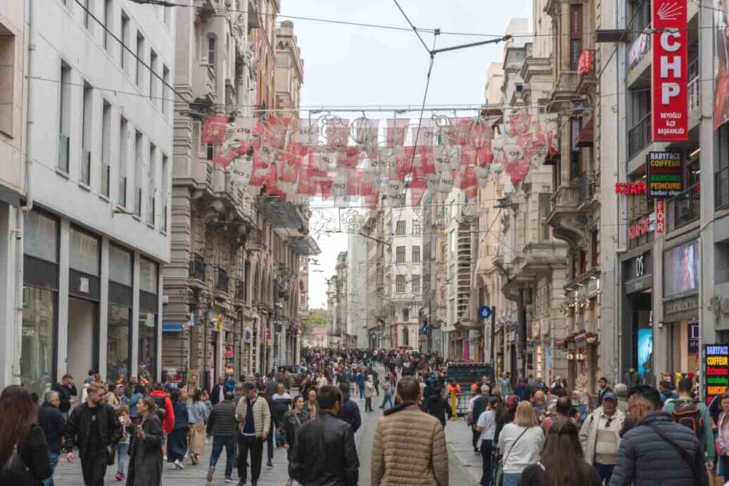 Un viale pedonale pieno di gente, negozi e palazzi storici, che si estende per circa 1,5 km