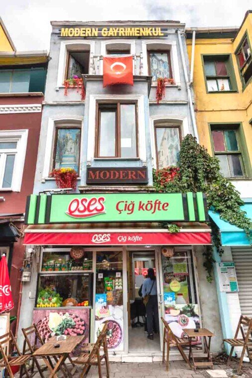 Pittoresca facciata di una palazzina che pubblicizza un bar sottostante.