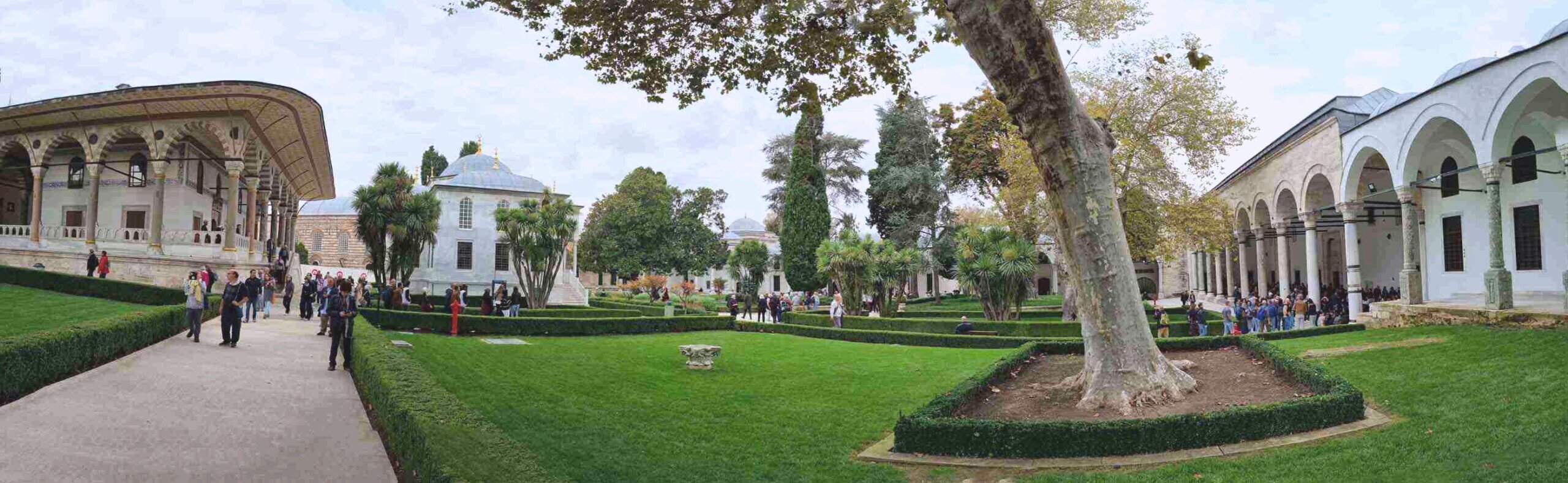 Ampio giardino con prati verdi e alberi, palazzi con arcate tipicamente ottomane.