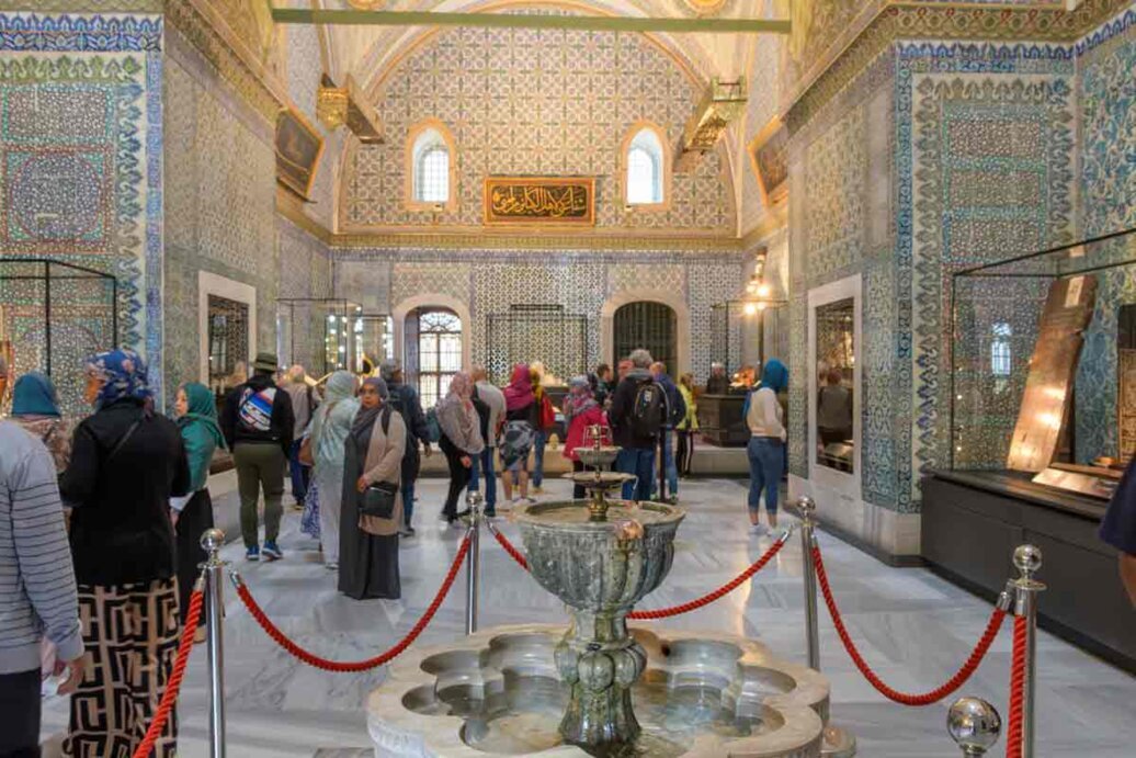 La sala d'ingresso all'esposizione delle reliquie con pareti rivestite di piastrelle fittamente decorate con prevalenza del colore blu.