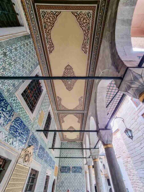 Sotto il portico del cortile degli eunuchi, con dettagli architettonici e decorazioni in ceramica blu,