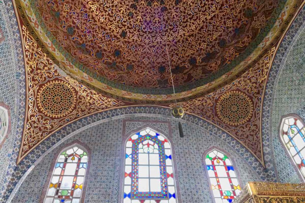 Cupola con decorazioni intricate rossastra, con in basso grandi finestre con vetri decorati.