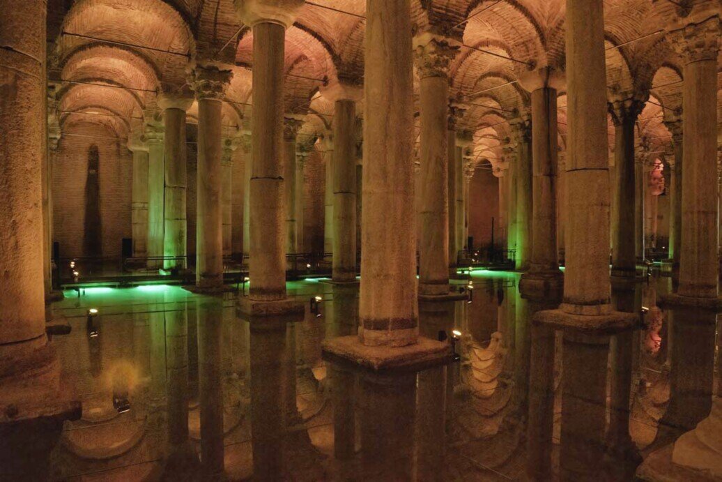 Interno della Basilica Cisterna di Istanbul con colonne illuminate e riflessi sull’acqua, antica cisterna bizantina sotterranea